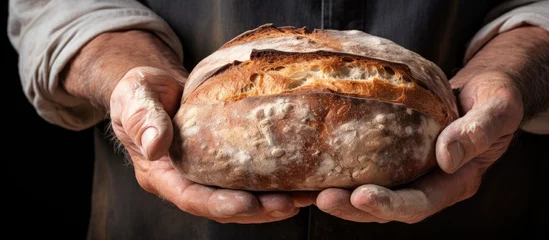Rolgordijnen An elderly person holding a bread loaf © AkuAku