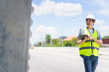 Obraz premium Professional senior Asian civil engineer working at the heavy infrastructure construction site, civil engineer - foreman inspecting the segmentation construction bridge.