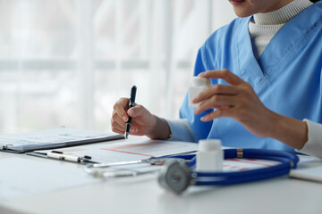 Doctors follow up on treatment, consult patients, and perform diagnostic work while writing...