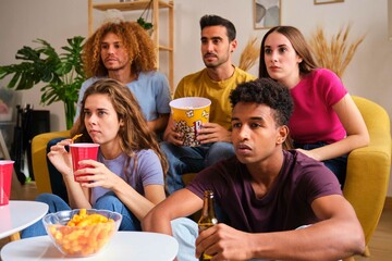 Group of friends watching a thriller interested stared intently.