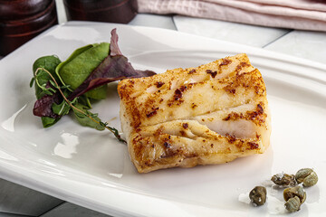 Roasted cod fish steak with salad