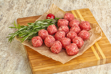 Raw uncooked beef meatballs served rosemary