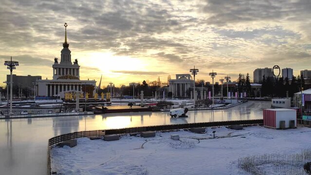 Open ice skating rink at VDNKh park at sunrise in winter. Ice resurfacer is preparing the surface for visitors