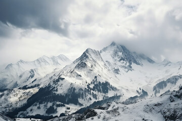 High angle shot of a beautiful mountain range covered with snow under the cloudy sky, aesthetic look