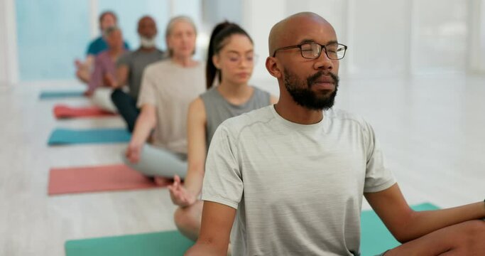 Man, coach and zen meditation in yoga class for spiritual wellness, awareness or stress relief. Calm male person or yogi with group in mediating with healthy mind, body and health for indoor fitness