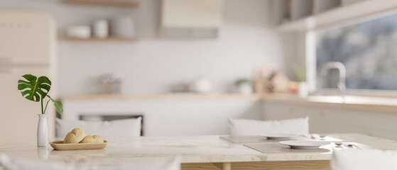 Close-up image of sets of tableware on a luxury white marble dining table in a modern white kitchen.