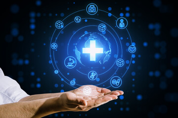 Close up of businessman hands holding creative glowing blue medical hologram with cross and globe on blurry background. Science, healthcare system and futuristic pharmacy concept.