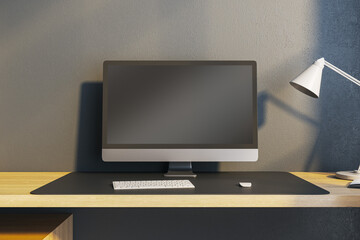 Close up of contemporary workplace with empty mock up computer monitor and lamp. 3D Rendering.