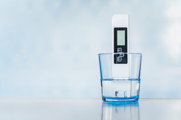 TDS measurement of water. Electronic pH meter in a glass of water. poor water quality, high values...