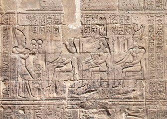 Ancient Egyptian bas-relief on stone wall. Figure of the pharaoh making ritual offerings to the...