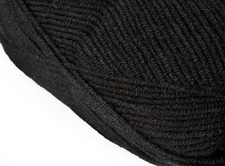 A skein of black wool blend yarn on a white background.