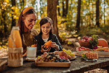 Mother and her daughter on a picnic in a forest