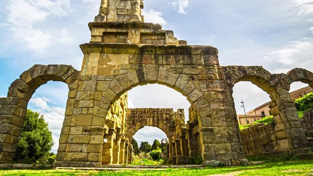 Timelapse of the ancient ruins of the beautiful Tindari Greek Theatre in tindari, sicily with moving clouds and the ancient architecture on a warm day during an adventurous trip