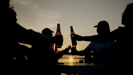 Group of friends playing guitar and drinking beer on silhouette sunset background beautiful nature, mountains and lake,Friendship and celebration concept. - Powered by Adobe