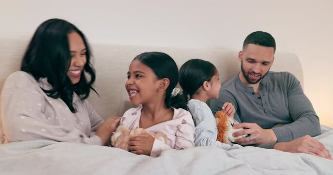 Happy family, fun and playing in a bed with hand, games or comic in their home together. Love, relax and children with parents in a bedroom with weekend tickle, laughing and bonding in their house