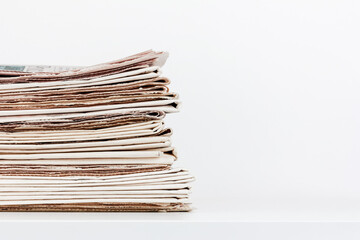 a stack of newspapers on a table on a white background with a copy space