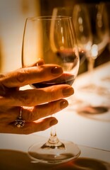 Mature female in a close-up shot, holding a glass of wine in her hand