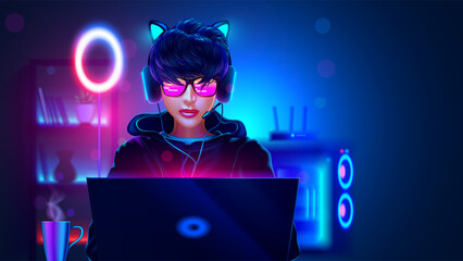 Gamer girl with laptop in dark room with neon lights. Girl teen in hoodie play online video games on laptop at night. Gamer in headphones look at laptop. Video Gamer Room with gaming PC computer.