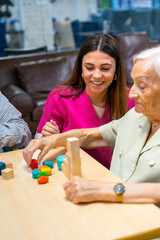 Nurse helping elder people to play in a nursing home
