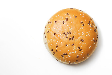 Burger bun isolated on white. Fastfood background. Hamburger bread roll. Sweet baked hamburger roll on white table. Sprinkled with seeds. Empty copy space food background.