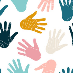 Fototapeta premium Hands of people of different nationalities form a seamless abstract pattern with multi-colored palms on a white background for textile. 