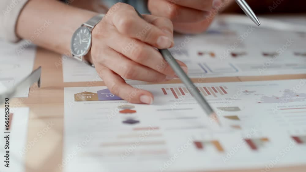 Poster close up slowmo of female hand with watch pointing at bar charts in documents with pencil while disc