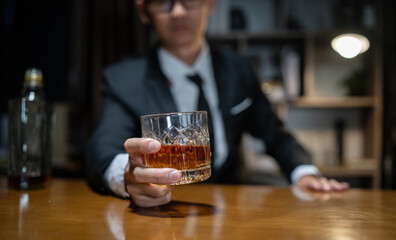 Businessman wearing a suit whiskey glass of liquor.
