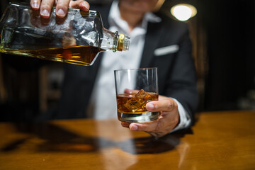 Businessman wearing a suit whiskey glass of liquor.