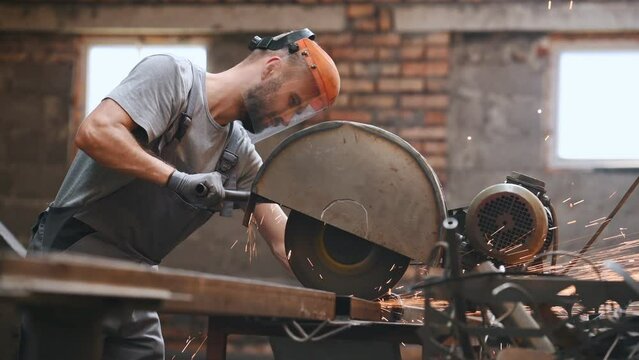 worker cuts metal on a circle and a circular saw. steel pipes and cylindrical blanks for welding