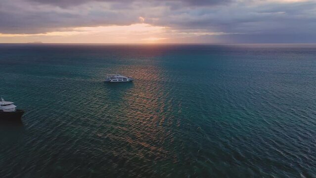 Port of Lazi at sunset, Siquijor Island, Philippines. Aerial drone view. Leisure and travel ferry boats at shore. Vibrant colorful clouds at dusk.