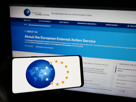 Stuttgart, Germany - 10-16-2023: Person holding smartphone with logo of EU institution European External Action Service (EEAS) in front of website. Focus on phone display.