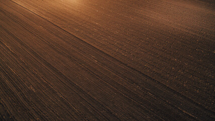Aerial shot of tilled agricultural field prepared for sowing season, drone pov - obrazy, fototapety, plakaty
