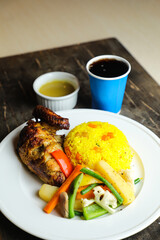 Rice with chicken Roast Meal with salad served in plate with sauce, cold drink, spoon and fork isolated on wooden board side view of thai food