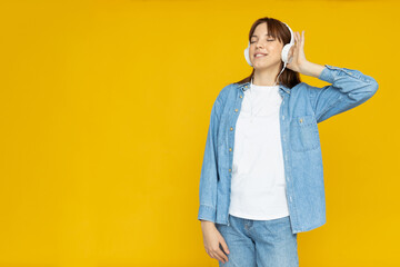 Attractive young girl listens to music in headphones