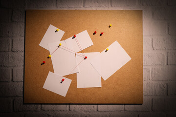 The papers are connected with threads on the board