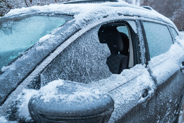 frozen car after snowstorm with broken window