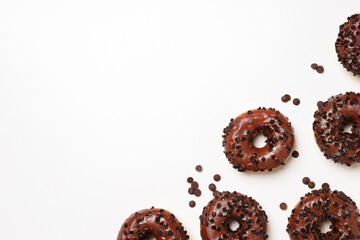 Chocolate donuts and chocolate chips on white background, space for text