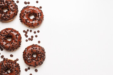 Chocolate donuts and chocolate chips on white background, space for text