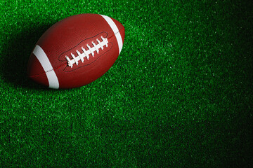 American football ball isolated on green grass