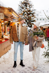 Beautiful couple with bouquet walking at the christmas market