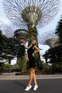Young slim blonde woman girl takes selfie photo pictures near Gardens by the Bay and Marina Sands hotel in Singapore
