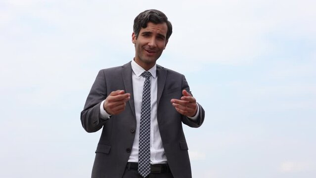 Modern businessman smiles and stretches his hand to the camera wishing to greet