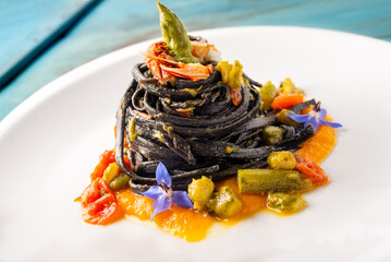 Deliziosi tagliolini al nero di seppia con salsa di scampi e asparagi selvatici, ricetta gourmet di...