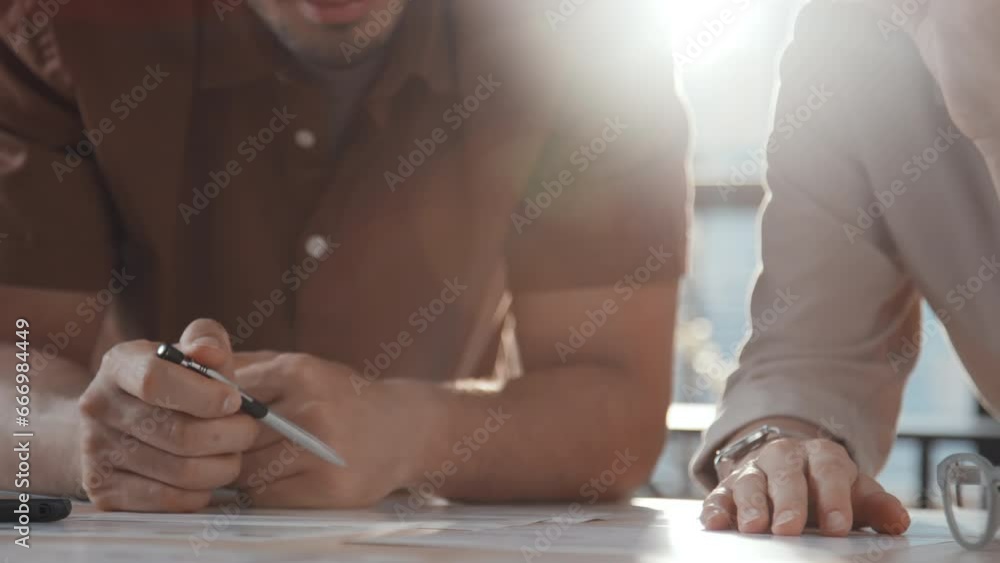 Poster midsection slowmo of two unrecognizable colleagues in casual wear leaning on table and planning proj