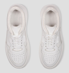 stylish white female sneakers with laces isolated on a white background