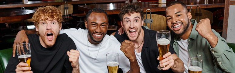 banner of excited interracial friends cheering with glasses of beer in bar, men on bachelor party