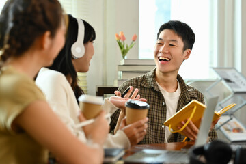 Shot of happy business colleagues sharing ideas or discussing plans during coffee break