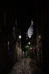 Ruelle de Montmartre avec la basilique sacré-cœur de nuit