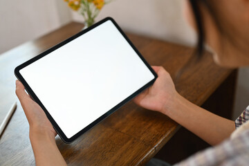 Close up shot of female freelancer holding digital tablet with blank screen
