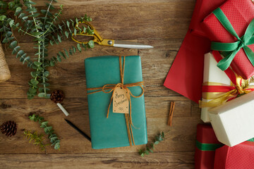 Christmas present wrapped in turquoise paper on table, view from above